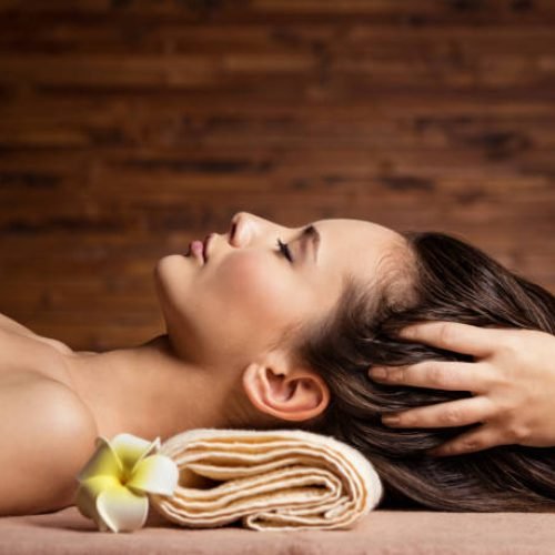 Masseur doing massage the head and hair for an woman in spa salon